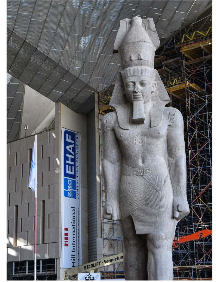A large ancient Egyptian statue within a museum.