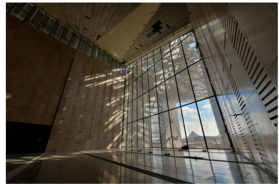 A large room, a few stories tall, with one wall replaced with a massive window spanning from floor to ceiling.
