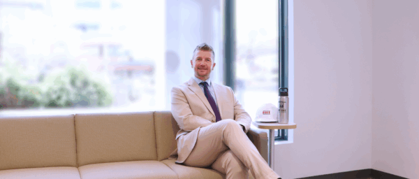 Man in a suit sitting on a couch in an office